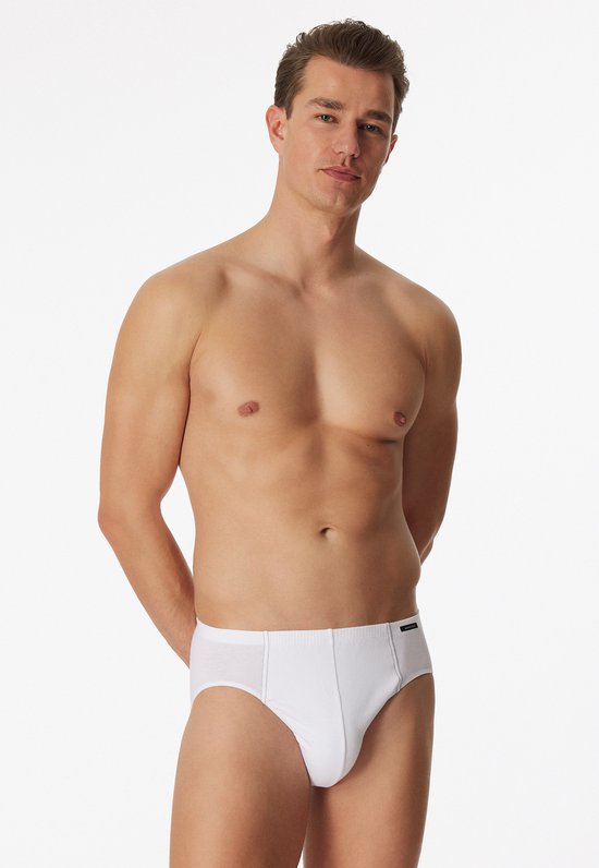Man met handen achter de rug, draagt witte Schiesser slips.