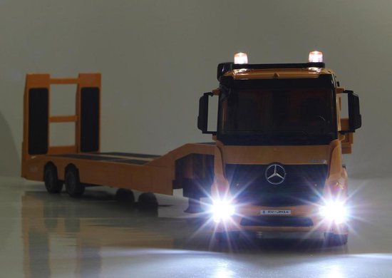 Gele Mercedes-Benz Arocs dieplader speelgoed vrachtwagen met koplampen en zwaailichten aan.