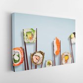 Traditional japanese sushi pieces placed between chopsticks, separated on light blue pastel background. Very high resolution image. - Modern Art Canvas  - Horizontal - 1090150760 -