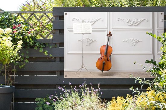 Tuinposter 180x120 cm - Tuindecoratie Een cello tegen een witte muur - Poster voor in de tuin - Buiten decoratie - Schutting tuinschilderij - Tuindoek muurdecoratie - Wanddecoratie balkondoek