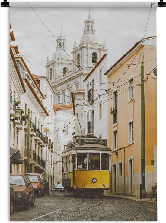 Tram jaune roulant sur des rails dans une rue étroite de Lisbonne, avec des bâtiments et une église.