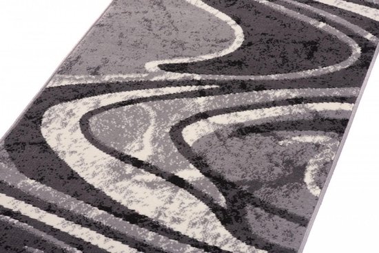 Tapis gris à motif ondulé abstrait dans les tons gris foncé, gris clair et blanc.