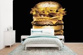 Behang - Fotobehang Gouden hamburger op een zwarte achtergrond. - Breedte 400 cm x hoogte 240 cm