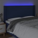 Tête de lit bleue en tissu avec un subtil éclairage LED bleu au-dessus du lit, avec couette.
