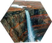 Dibond Hexagon - Hoge Smalle Waterval van Donkerkleurige Rotsen - 80x69.6 cm Foto op Hexagon (Met Ophangsysteem)