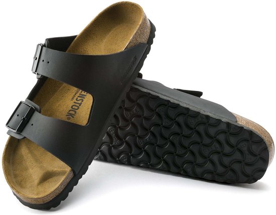 Zwarte Birkenstock slippers, de ene met zool omhoog, de andere met bovenkant naar boven.