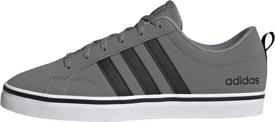 Baskets Adidas grises avec rayures noires sur le côté et une semelle blanche.