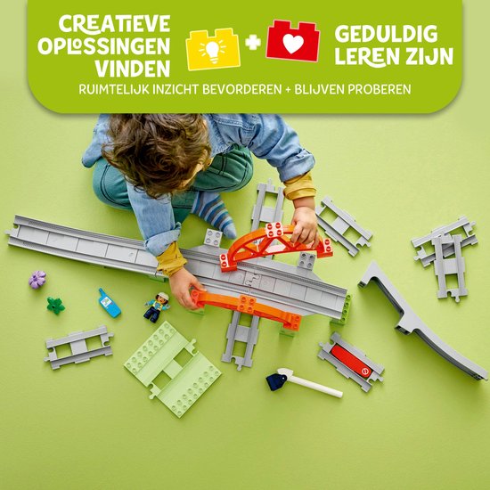 Kind bouwt met LEGO Duplo treinonderdelen: spoorrails, brug, overweg, bloem en figuur.