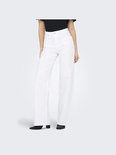 Model draagt een wijde, witte jeans met hoge taille.