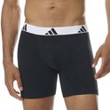 Man draagt een zwarte boxer met witte band en zwarte Adidas logo's.