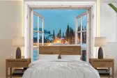 Behang - Fotobehang Doorkijk - Winterlandschap - Natuur - Huis - Bergen - Breedte 350 cm x hoogte 350 cm