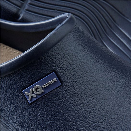 Detail van een navy XQ Footwear klomp met textuur en logo.