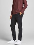 Man met bordeauxrode longsleeve en zwarte chino, zijaanzicht.