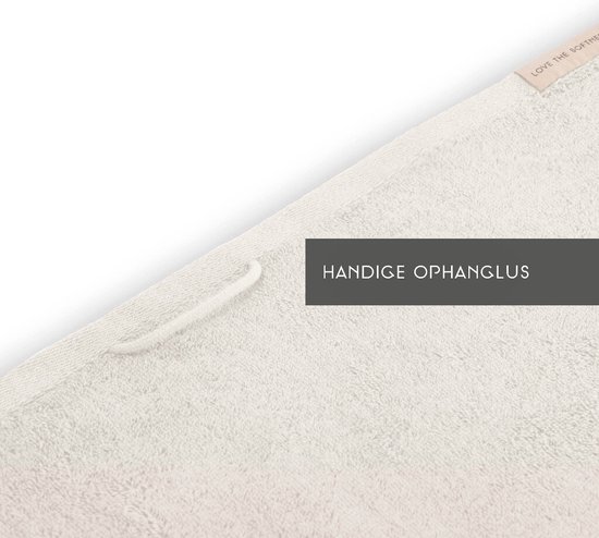 Crèmekleurige handdoek met een lussenophanging en een label 'LOVE THE SOFTNESS'.