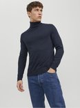 Man met donkerblauwe coltrui en spijkerbroek