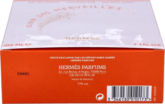 Zijkant van de oranje Hermès Elixir des Merveilles parfumverpakking met productinformatie.