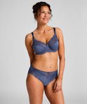 Model draagt een blauwe bh met stippenpatroon en kanten details, met bijpassende slip.