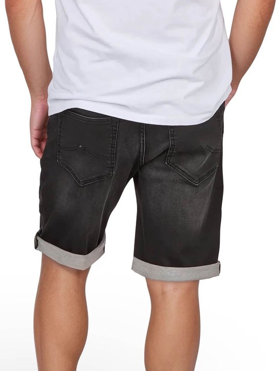 Achterkant van een man met grijze denim short met omgeslagen broekspijpen.