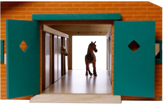 Gezicht op een houten paardenstal met rode bakstenen façade, groene deuren open, bruin paard in hal.