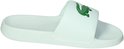 Witte Lacoste slipper met groene krokodil op de band en 'Lacoste' tekst op de zool.