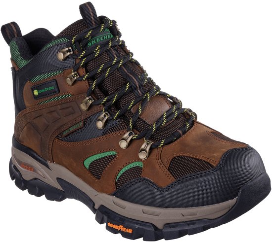 Botte de travail en cuir marron avec accents verts et noirs, logo John Deere et semelle Goodyear.
