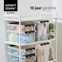 Drie rekken vol met diverse doorzichtige opbergboxen, gevuld met speelgoed zoals auto's, knuffels en bowlingkegels.