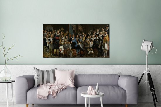 Peinture du Banquet des Mousquetaires célébrant la Paix de Münster par Bartholomeus van der Helst, sur un mur au-dessus d'un canapé gris.