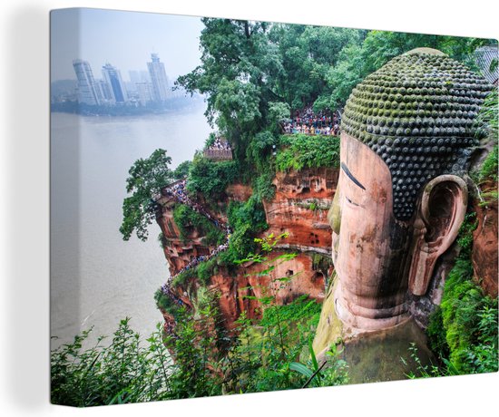 Canvas Schilderij De Aziatische Grote Boeddha van Leshan met de stad op de achtergrond in China - 90x60 cm - Wanddecoratie