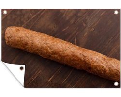 Tuinposter - Tuindoek - Tuinposters buiten - Een heerlijke frikandel op een houten achtergrond - 120x80 cm - Tuin