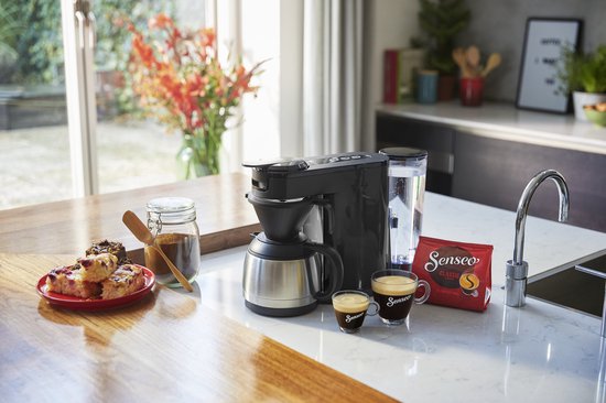 Zwart Senseo koffiezetapparaat met thermokan, twee glazen Senseo mokken en Senseo koffiepads in een keuken.