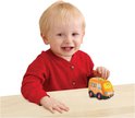 Jongetje in rode trui kijkt lachend naar een oranje VTech Boris Bestelbus speelgoed auto op een houten tafel.