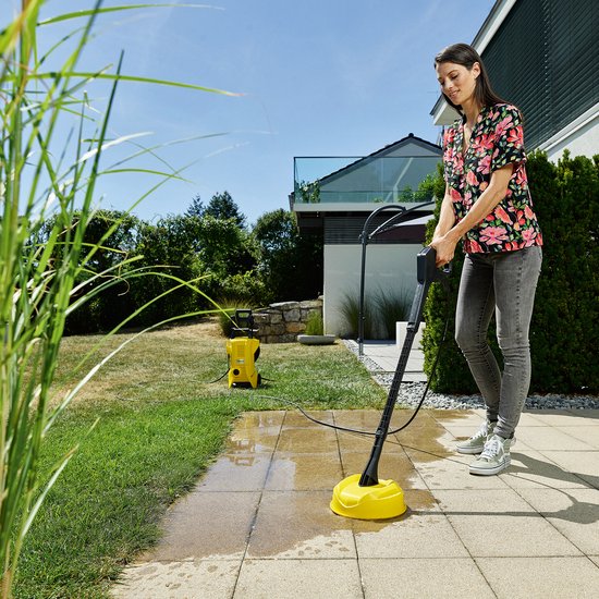 Vrouw met gebloemd shirt gebruikt terrasreiniger.