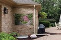 Une affiche de jardin représentant un passage circulaire en pierre avec des arbres roses en fleurs à travers.