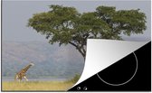 KitchenYeah® Inductie beschermer 80x52 cm - Een giraffe op de savanne van het Nationaal park Murchison Falls - Kookplaataccessoires - Afdekplaat voor kookplaat - Inductiebeschermer - Inductiemat - Inductieplaat mat