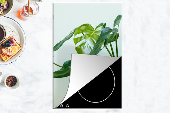 KitchenYeah® Inductie beschermer 30x52 cm - Monstera in een pot met een lichte achtergrond - Kookplaataccessoires - Afdekplaat voor kookplaat - Inductiebeschermer - Inductiemat - Inductieplaat mat