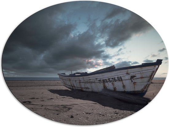 WallClassics - Dibond Ovaal - Witte Boot op het Strand onder Donkere Wolken - 80x60 cm Foto op Ovaal (Met Ophangsysteem)