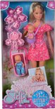 Doos met Steffi Love pop als babysitter. Ze draagt een roze jurk en een babydrager met baby. Een wiegje met baby staat naast haar.