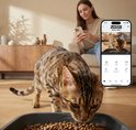 Een bengaalse kat eet uit een voerbak, een smartphone toont de Zedar app.