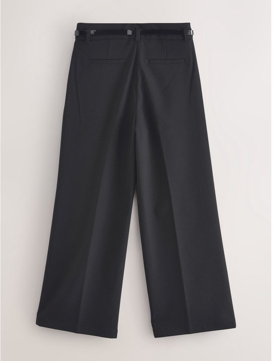 Achterkant van een zwarte wijde broek met riem en twee zakken op de achterkant.