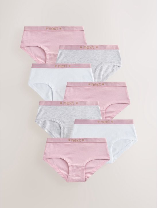Set van zeven meisjesonderbroeken in roze, lichtgrijs en wit, elk met een roze tailleband met 'next' en hartjes.