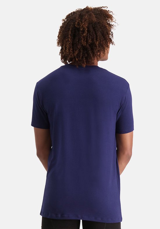 Achterkant van een man die een marineblauwe T-shirt met ronde hals draagt.