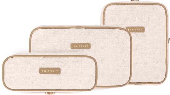 Drie off-white packing cubes met goudkleurige ritsen en label, op een witte achtergrond.