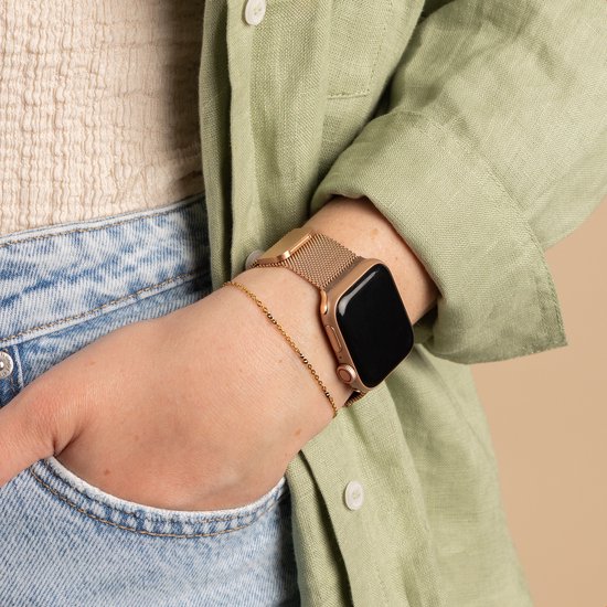 Rosegouden Milanese bandje om een pols met een lichtgroen shirt en een blauwe jeans. Met bijpassend armbandje.