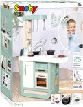 Doos van de Smoby Cherry speelkeuken met een jongen die een vork omhoog houdt en informatie over 25 accessoires.
