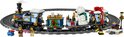 Gedetailleerde LEGO Icons Feestelijke Kersttrein in blauw met gouden details, wagons met cadeaus en een ijsbeer, op een cirkelvormig spoor.