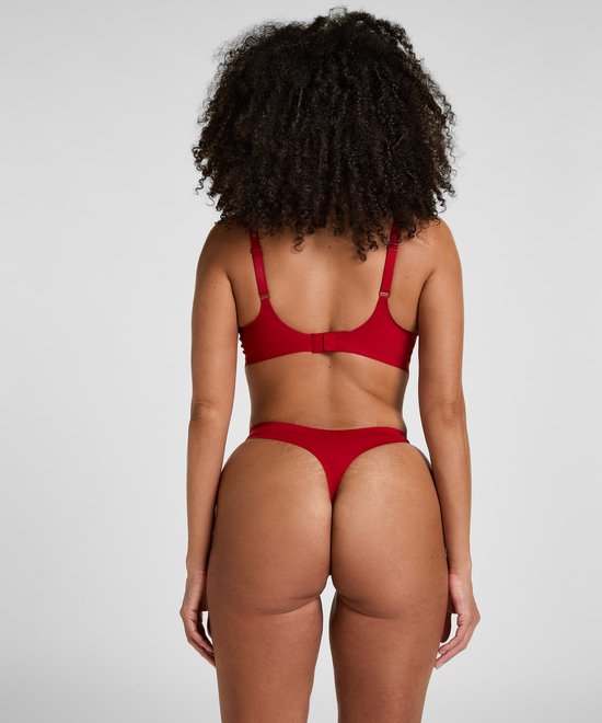 Model van achteren, draagt rode string met bijpassende beha.