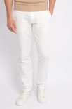 Man in een witte chinobroek en witte sneakers.