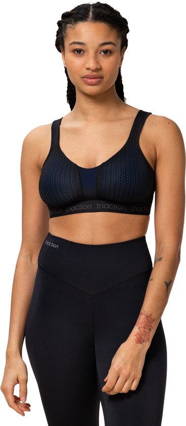 Vrouw draagt zwarte sportbeha met blauw accent en dot-patroon. 'triaction' logo op de band.