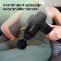 Vrouw met witte koptelefoon gebruikt de zwarte 2BEHEALTHY massagegun XG10 op haar bovenbeen voor spierherstel.