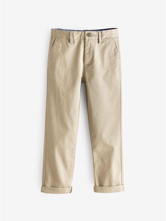 Een beige chino broek met opgerolde broekspijpen, een knoop en ritssluiting.